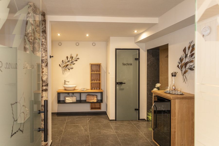 Wellnessbereich mit Waschbecken und Getränkekühlschrank